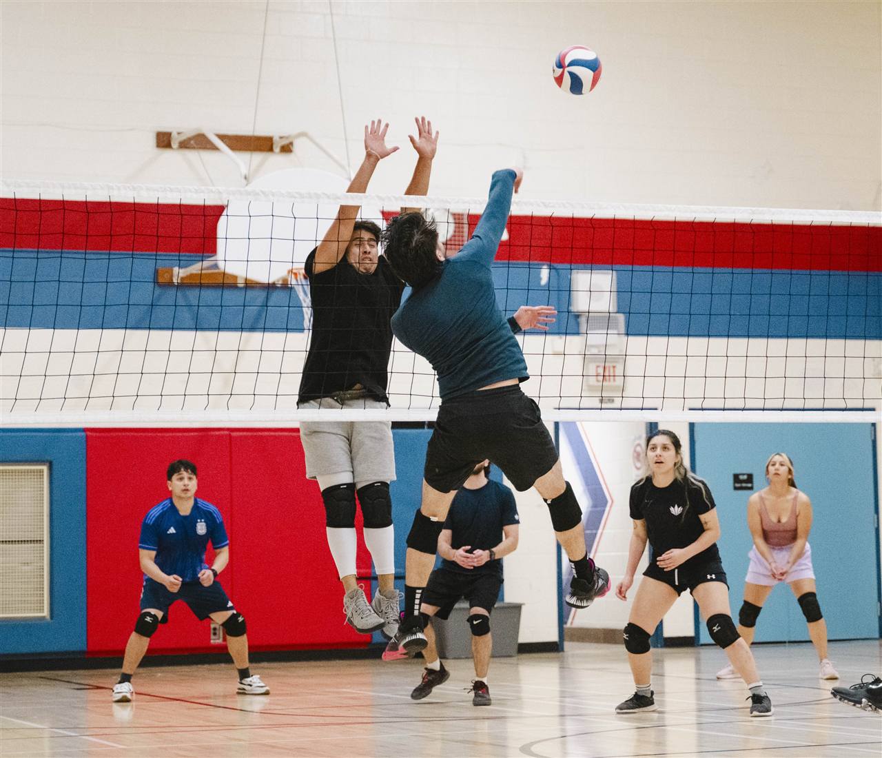 Players at the net during a Mississauga Volleyball League match